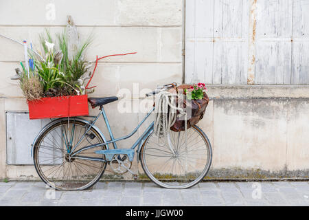 Alten altmodischen blaue Dame Fahrrad mit flachen Reifen geparkt lehnt gegen eine Wand, Pauillac, Gironde Abteilung, Nouvelle-Aquitaine, Südwestfrankreich Stockfoto