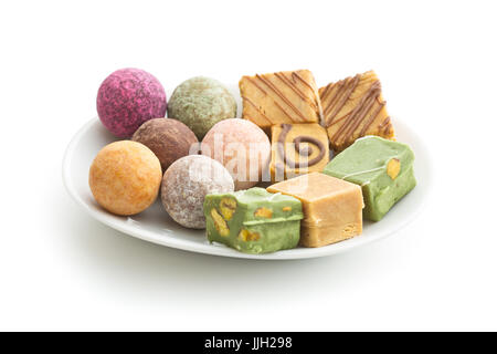 Verschiedene süße Bonbons auf Platte isoliert auf weißem Hintergrund. Stockfoto