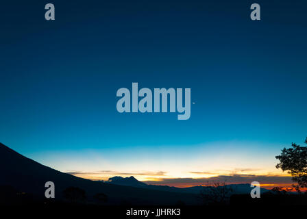 Sonnenaufgang Wolken und Berge in Guatemala, dramatischer Himmel mit auffälligen Farben und Mond. La Réunion. Stockfoto