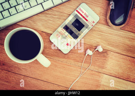 Fernseher zum Verkauf angezeigt auf Bildschirm des Geräts gegen weiße Smartphone mit Tasse Kaffee Stockfoto