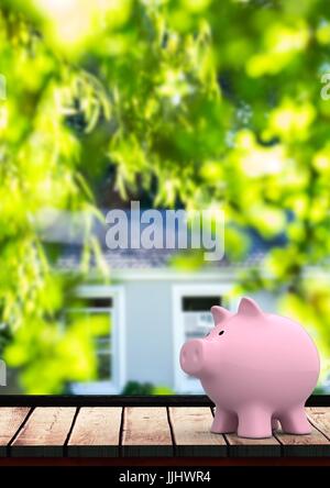 Rosa Sparschwein gegen Haus mit leafs(blurred) Stockfoto