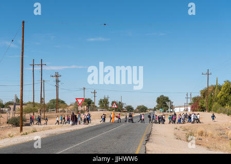 MARCHAND, Südafrika - 12. Juni 2017: Schulkinder überquert die Hauptstraße am Marchand, einem Dorf in der Provinz Northern Cape Stockfoto