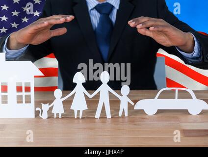 Business-Mann zeigt eine Papier-Familie gegen amerikanische Flagge Stockfoto