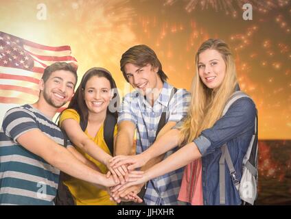 Freunde mit Händen gemeinsam gegen amerikanische Flagge und Feuerwerk Stockfoto