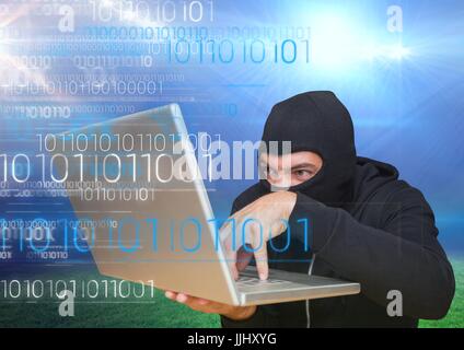 Hacker mit einem Laptop vor Wiese Stockfoto