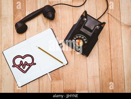 Herz-Doodle auf Notizblock neben Schwarz Vintage Telefon Stockfoto