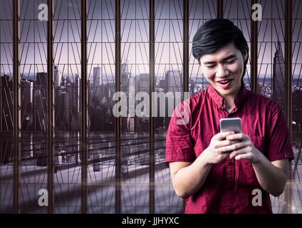 Lächelnder Mann SMS mit Stadt im Hintergrund Stockfoto