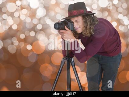junge Hipster Fotograf mit Hut, ein Foto mit dem Stativ. Braune bokeh Stockfoto