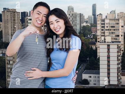 Paar Holding Apartmentschlüssel mit Stadt Stockfoto