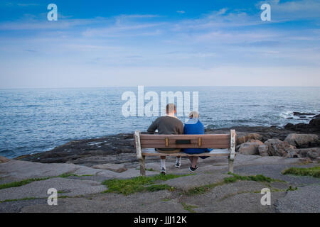 Zwei liebende, die friedlich sitzen auf einer Bank am Meer Stockfoto