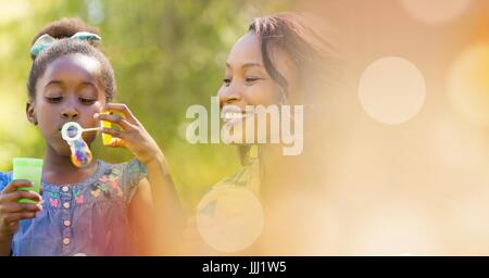 Mutter und Tochter Seifenblasen mit Pfirsich Bokeh Übergang Stockfoto