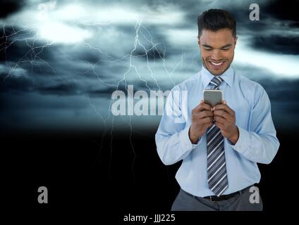 Lächelnder Mann SMS in der Dunkelheit mit Lastenerleichterungen Stockfoto