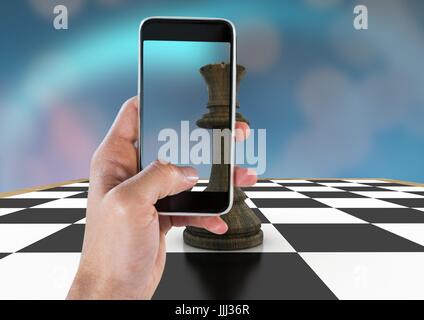 Hand mit Handy gegen Schach Stück und blau bokeh Stockfoto