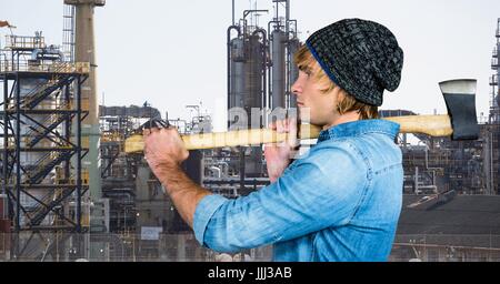 Seitenansicht des männlichen Hipster mit Axt gegen Fabrik Stockfoto