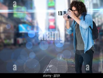 Fotograf in der Stadt fotografieren. Unscharfe Lichter und Fackeln überall. Stockfoto