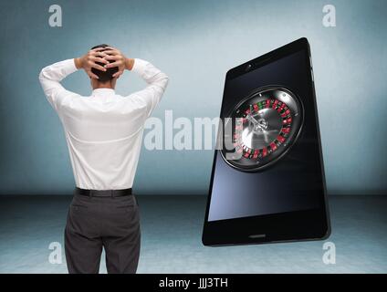 Rückseite des Mannes Blick auf 3d Casino Roulette auf Handy Stockfoto