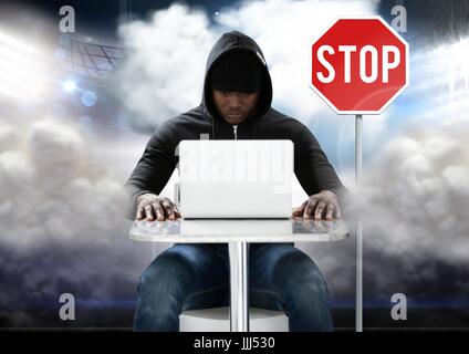 Hacker arbeiten am Laptop vor Stop board Stockfoto