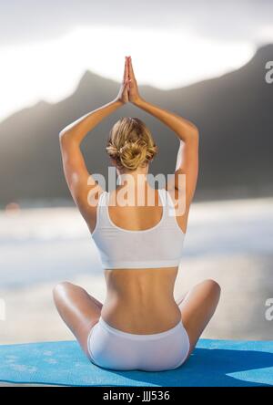 Rückseite der Frau meditieren am Strand Stockfoto