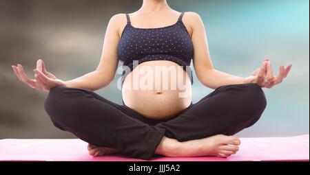 Schwangere Frau Mittelteil meditieren verschwommene blaue braunen Hintergrund Stockfoto