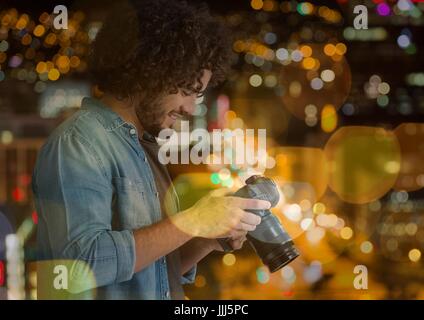 Fotograf auf der Suche um die Fotos vor der Kamera, in der Stadt in der Nacht (mit verschwommenen Lichtern) Stockfoto