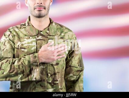 Teil eines Soldaten mit der Hand auf das Herz gegen die amerikanische Flagge flattern Stockfoto