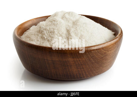 Weißer Reismehl in dunklen Holzschale isoliert auf weiss. Stockfoto