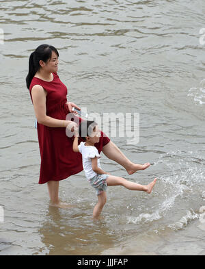 Peking, China. 19. Juli 2017. Eine Mutter und ihr Sohn spielen Wasser in der Nähe der Chaotianmen-Werft in Südwest-China Chongqing Stadtbezirk, 19. Juli 2017. Bildnachweis: Tang Yi/Xinhua/Alamy Live-Nachrichten Stockfoto