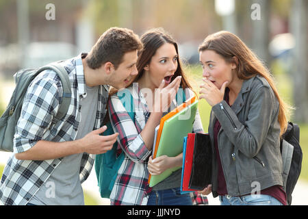 Drei Klatsch Studenten erzählen Geheimnisse auf der Straße Stockfoto
