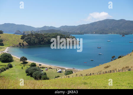 Blick auf Zelte und verankerte Boote im Sommer von Insel Urupukapuka Bay of Islands, New Zealand, Neuseeland Stockfoto