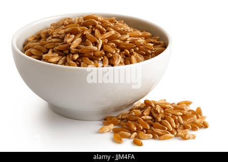 Kamut Weizenkörner in weiße Keramikschale, isoliert auf weiss. Verschüttete Weizen. Stockfoto