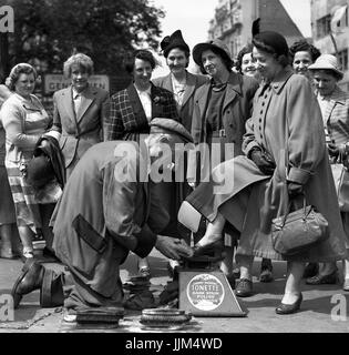 Deaktiviert Schuhputzmaschine/-Mann mit nur einem Bein polieren Damenschuhe auf einem Damen Mädchen Tag in London 1949 Schuhputzmaschine/-mann Stockfoto