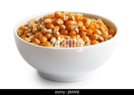 Unpopped Popcorn in weiße Keramikschale, isoliert auf weiss. Stockfoto