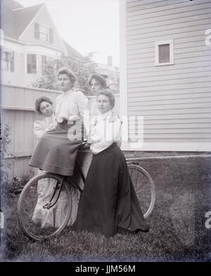 Antike c1910 Foto, vier Frauen auf ein antikes Fahrrad. Ort unbekannt, möglicherweise Rhode Island, USA. QUELLE: ORIGINALFOTO. Stockfoto