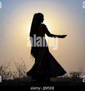 Eine Zigeunerin tanzen vor der untergehenden Sonne, Pushkar Camel Fair, Pushkar, Rajasthan, Indien Stockfoto