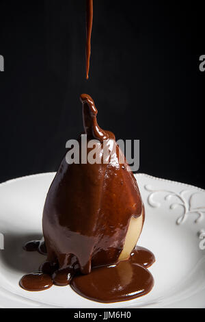 Pochierter Birne mit Schokoladensoße Stockfoto