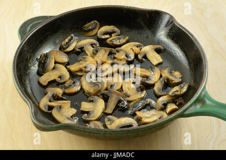 Sautierten geschnittenen weißen Champignons in Gusseisen Pfanne Stockfoto