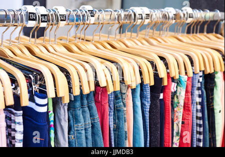 Bunte Freizeitkleidung auf Holzbügel im store Stockfoto