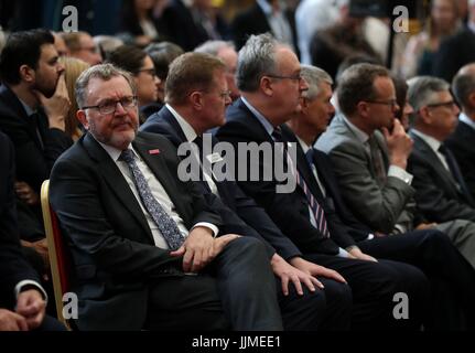 Staatssekretär für Schottland Sir David Mundell (L) Uhren einen Monitor im Rahmen einer Feierstunde Schneiden von Stahl auf der ersten Fregatte Typ 26 bei BAE Systems Govan Werft in der Nähe von Glasgow begann. Stockfoto