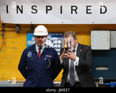 Staatssekretär für Schottland Sir David Mundell (R) plaudert mit BAE Systems Arbeiter James McDowall als das Schneiden von Stahl auf der ersten Fregatte Typ 26 bei BAE Systems Govan Werft in der Nähe von Glasgow begann. Stockfoto