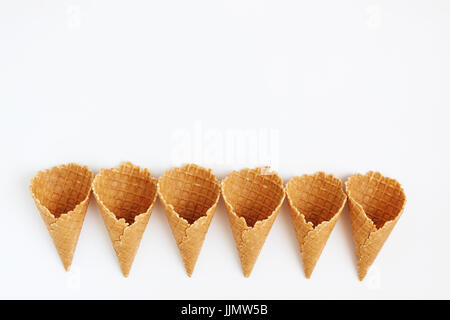 Mehrere Waffelkegeln mit Turm, Lächeln oder sogar Reihe, Draufsicht, isoliert auf weißem Hintergrund gefüttert. Stockfoto
