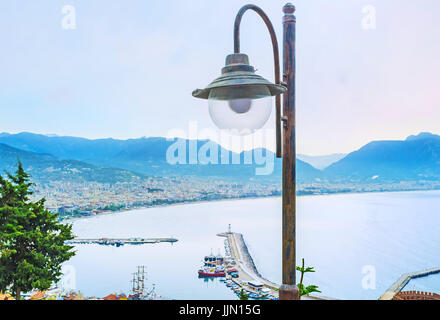 Der Blick auf Alanya Küste mit eine Straßenlaterne und nebligen Taurusgebirge im Hintergrund, Türkei. Stockfoto