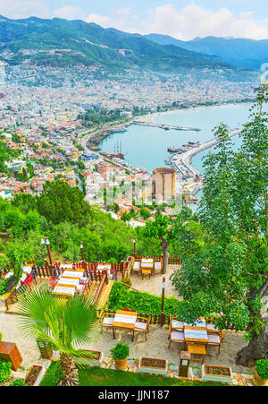 Die gemütlichen Restaurants auf dem Burgberg sind versteckt im Schatten der hiesigen Gärten und malerische Ausblicke auf die Altstadt von Alanya, Türkei öffnet. Stockfoto