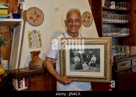 Antonio Bertoleoni, König der Insel Tavolara, das kleinste Königreich der Welt, mit der Fotografie seiner Vorfahren in seinem Stockfoto