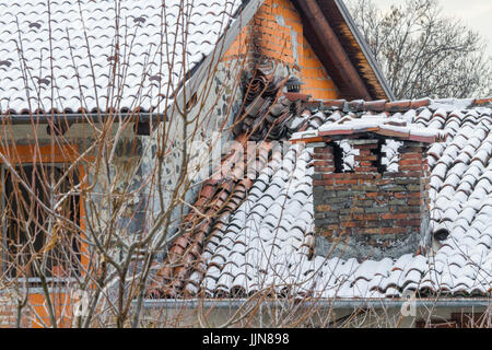 Große und alte gemauerte Schornstein mit Schnee, alte Dach mit großem Kamin Stockfoto