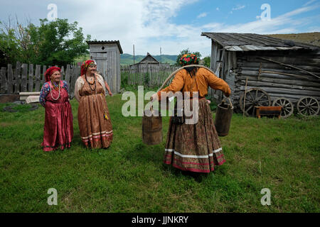 Russische Frauen in traditioneller Sarafankleidung im Dorf Sibirjachiha, dessen Mitglieder die altgläubigen Bräuche und Traditionen mit hunderten von Jahren zurückreichenden Fundamenten im Bezirk Soloneshenskiy der Region Altai in Westsibirien, Russland, bewahren. Die Alten Gläubigen oder Alten Ritualisten sind östliche orthodoxe Christen, die die liturgischen und rituellen Praktiken der russischen Kirche beibehalten, wie sie vor den Reformen des Patriarchen Nikon von Moskau zwischen 1652 und 1666 waren. Stockfoto