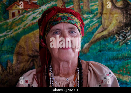 Eine ältere russische Frau in traditionellem Sarafankleid im Dorf Sibirjachiha, dessen Mitglieder die Bräuche und Traditionen der Altgläubigen mit hunderten von Jahren zurückreichenden Fundamenten bewahren, befindet sich im Bezirk Soloneshenskiy der Region Altai in Westsibirien, Russland. Die Alten Gläubigen oder Alten Ritualisten sind östliche orthodoxe Christen, die die liturgischen und rituellen Praktiken der russischen Kirche beibehalten, wie sie vor den Reformen des Patriarchen Nikon von Moskau zwischen 1652 und 1666 waren. Stockfoto