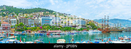 Panorama des Fischereihafens in alten nur mit zahlreichen Motorboote, hölzerne Touristenschiffe, Reihe von modernen Hotels an der Küste und Castle Hill auf backgr Stockfoto