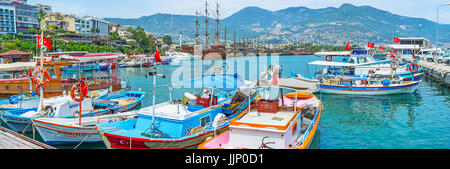 ALANYA, Türkei - 9. Mai 2017: Der Blick auf die Fischerboote im alten Hafen mit touristischen hölzerne Galeonen und Cilician Bergkette im Hintergrund, am Mai Stockfoto