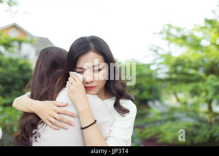 Freundschaft-Hilfe. Deprimiert asiatische Frau umarmte ihre Freundin. Stockfoto