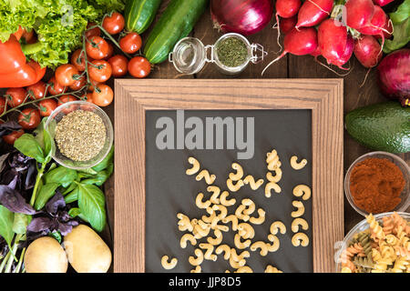 Über Ansicht von Essen Hintergrund mit natürlichen Gemüse, Gewürze und zwei Arten von italienischer Pasta an Tafel Stockfoto